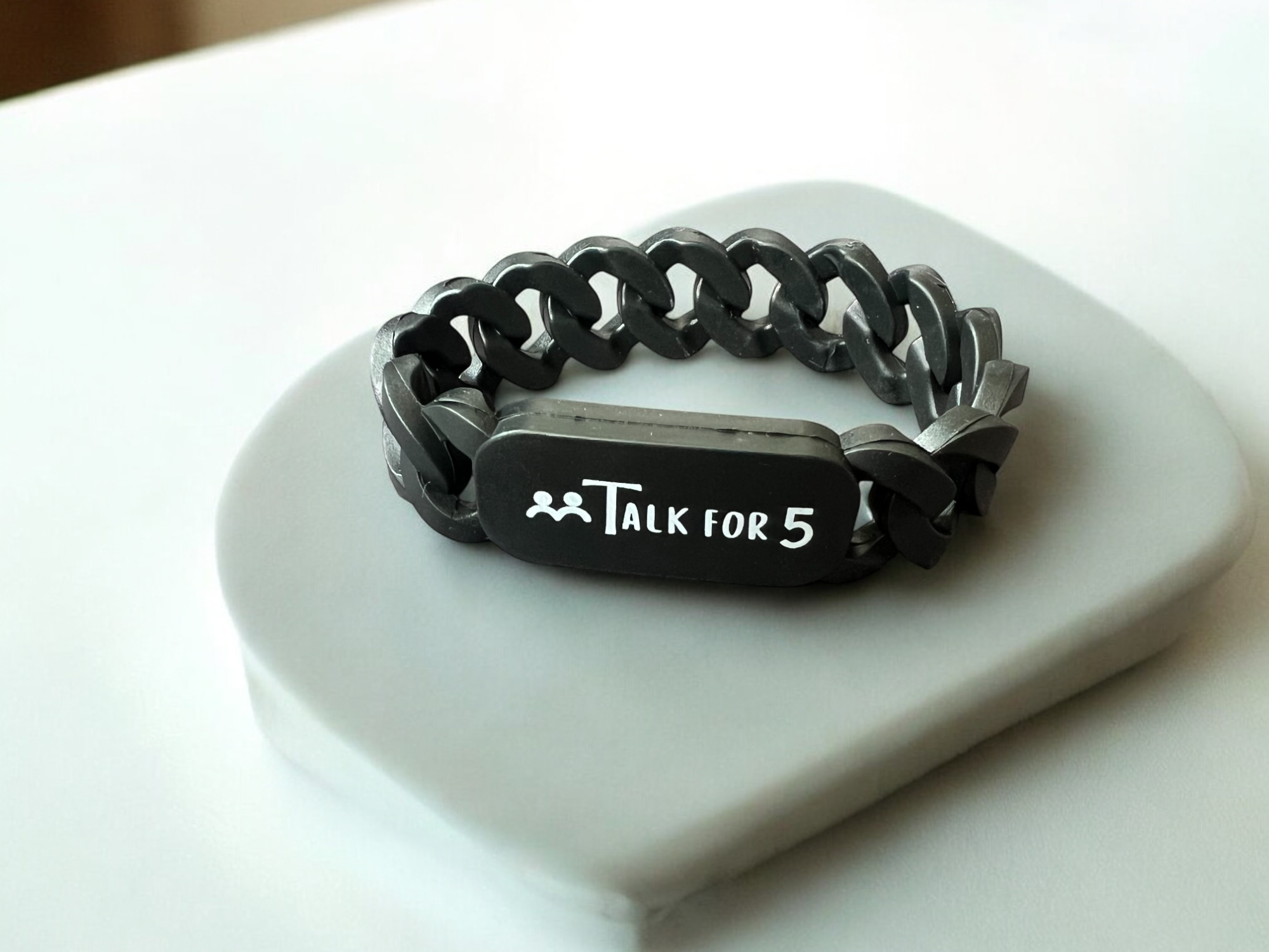 Black chain bracelet with 'Talk for 5' tag on a white surface, perfect for corporates, organizations and schools