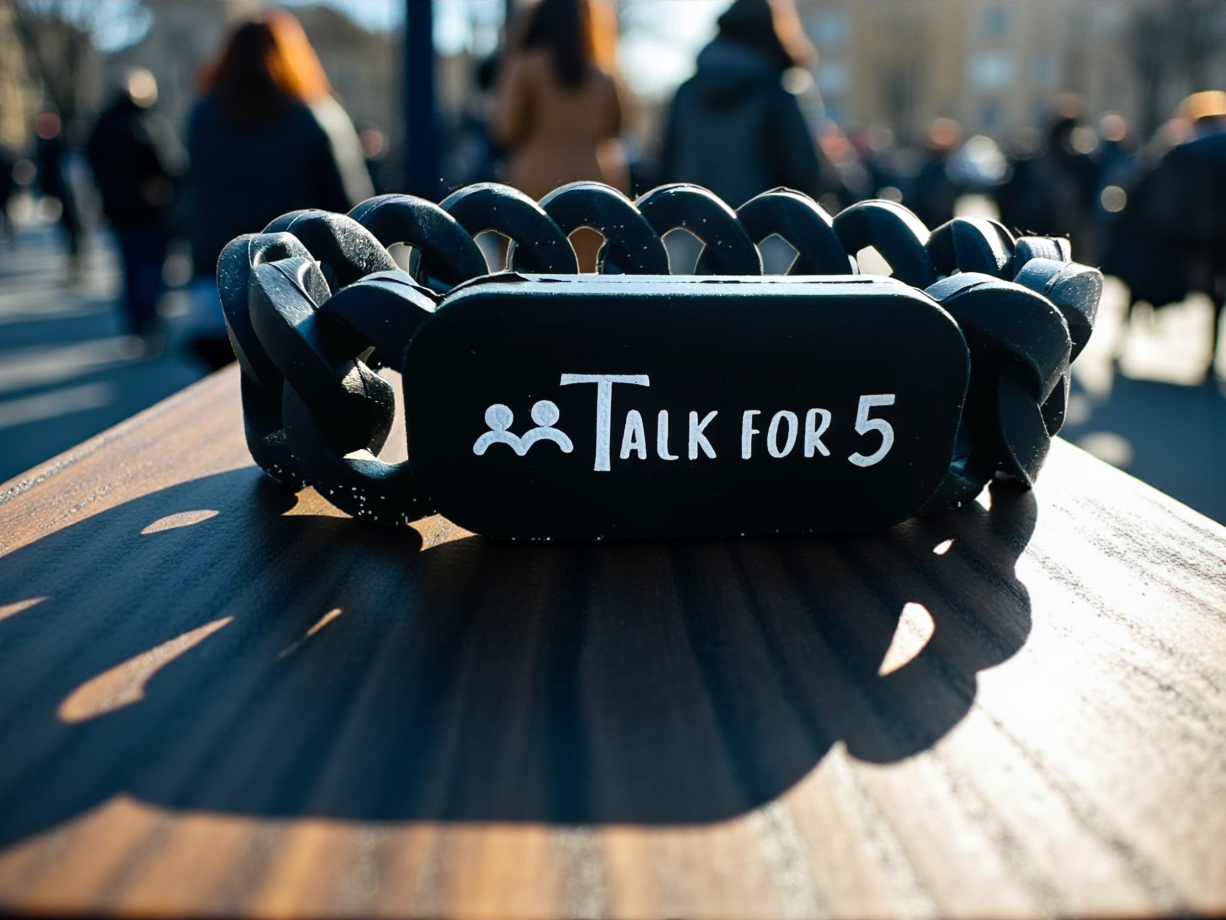 Black chain link wristband featuring Talk for 5 logo, designed to encourage mental health conversations and community support.